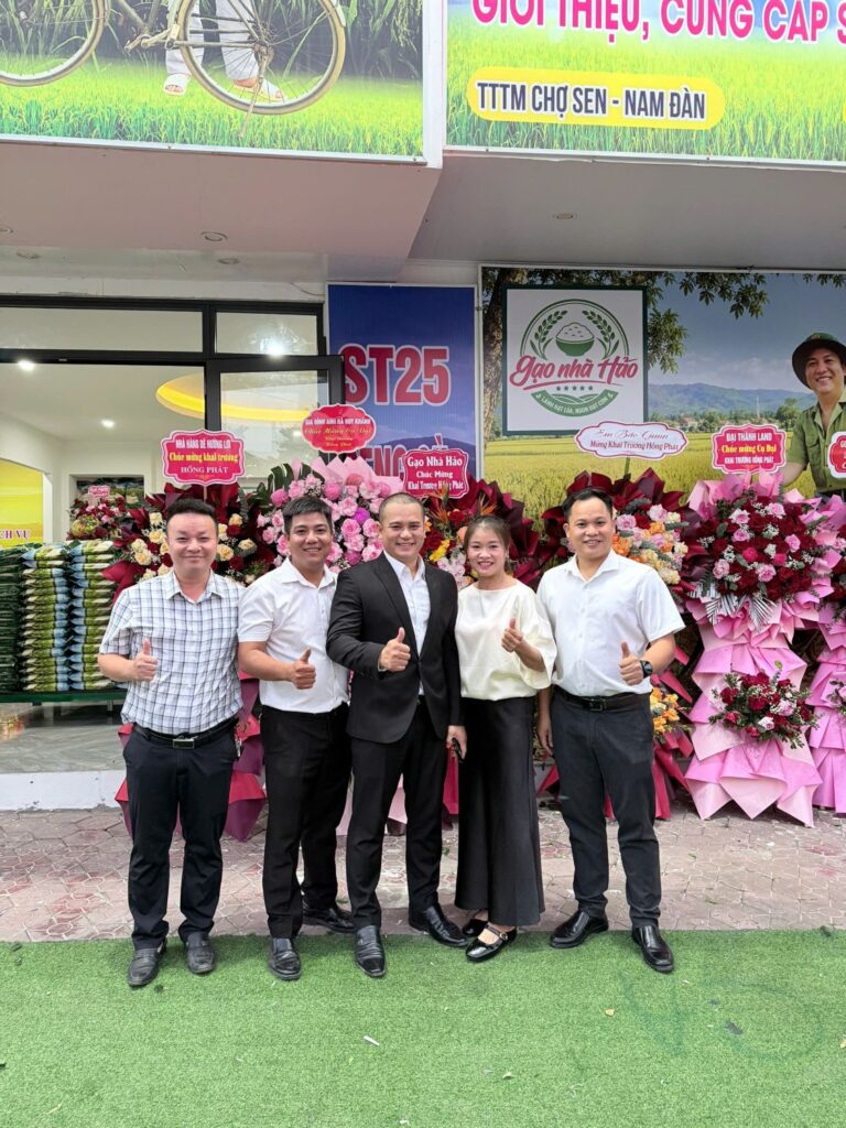 Bạn bè chụp ảnh chúc mừng trước biển Gạo Nhà Hảo và kệ gạo ST25 tại cửa hàng Cụ Đại Nghệ An